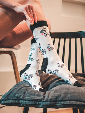 Weiße Socken mit Zebra-Motiv “Baby Zebra” von We are Socks! Frau mit Zebra-Socken.