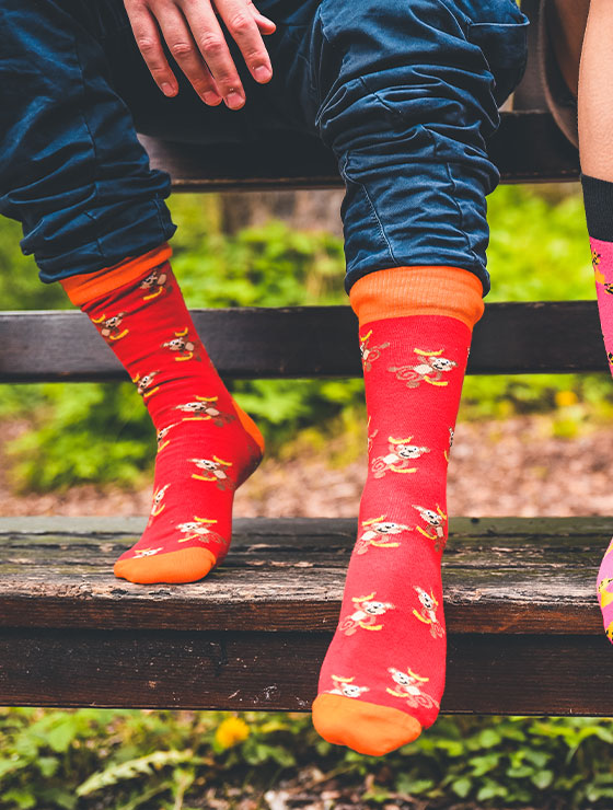 Rote Socken mit kleinen Affen die zwei Bananen in der Hand halten von We are Socks!